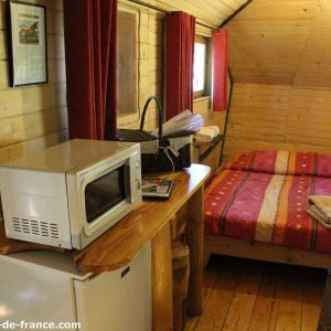 Cabane en bois cosy en Nouvelle-Aquitaine, avec lit douillet et kitchenette.