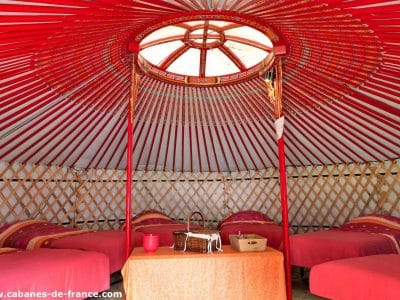 Yourte colorée avec des lits confortables, décorée de motifs traditionnels.