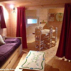 Cabane en bois colorée avec un coin salon et une table à manger décorée.