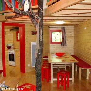 Cabane en bois colorée en Nouvelle-Aquitaine, avec un intérieur chaleureux et lumineux.
