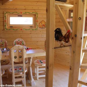 Cabane en bois en Nouvelle-Aquitaine, avec un poulet et une décoration colorée.