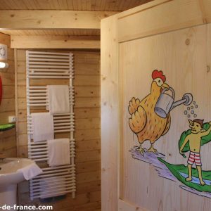 Cabane en bois à Nouvelle-Aquitaine, avec une porte décorée dun dessin coloré.