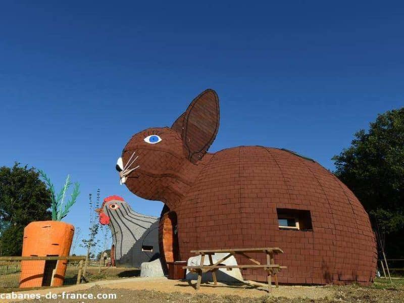 Hébergement insolite en forme de lapin, avec une carotte géante à proximité.