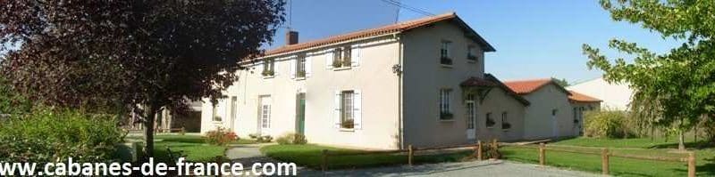 Charmante maison dhôtes avec jardin verdoyant et façade claire.