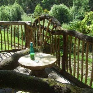 Cabane en bois dans le Limousin, avec une terrasse en rondins et vue sur la nature.