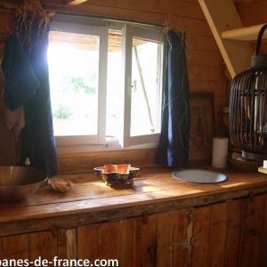 Cabane en bois au Limousin, avec une cuisine rustique et une lumière naturelle.