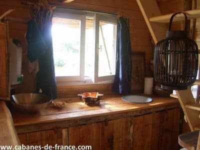 Cabane en bois au Limousin, avec une cuisine rustique et une lumière naturelle.
