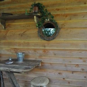 Cabane en bois à Limousin avec un miroir rond et une table rustique.
