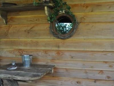 Cabane en bois à Limousin avec un miroir rond et une table rustique.