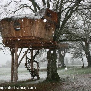 Cabane dans les arbres en bois, perchée, sous la neige dans le Pays de la Loire.