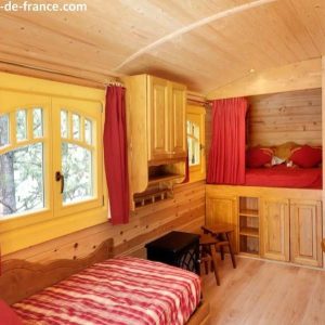 Hébergement insolite en cabane en bois, intérieur chaleureux avec lits superposés.