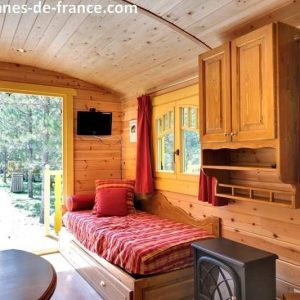 Cabane en bois chaleureuse avec un intérieur lumineux et vue sur la nature.