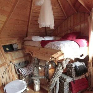 Cabane en bois avec lit surélevé et décoration rustique dans les Pays de la Loire.