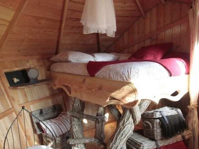 Cabane en bois avec lit surélevé et décoration rustique dans les Pays de la Loire.