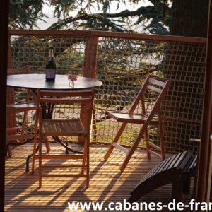 Cabane perchée en Auvergne, avec terrasse en bois et vue dégagée sur la nature.