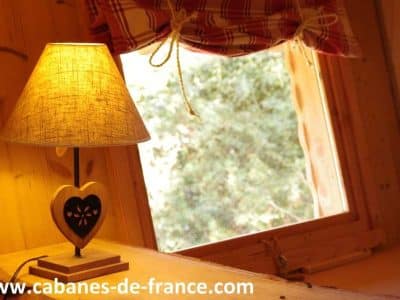 Cabanes en bois en Auvergne-Rhône-Alpes, avec une lampe au design chaleureux.