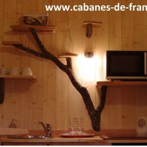 Hébergement insolite en cabane avec étagères en bois et décor naturel chaleureux.
