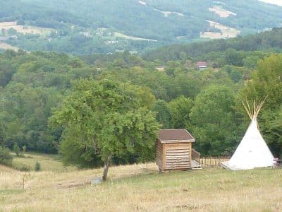 Teepee insolite à Limousin, entouré de verdure et de collines paisibles.