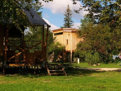 Hébergement insolite en Auvergne : cabane en bois avec vue sur la nature verdoyante.