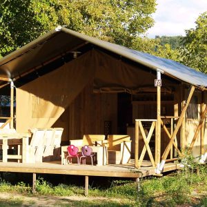 Tente safari en Auvergne, avec terrasse en bois et mobilier en plein air.
