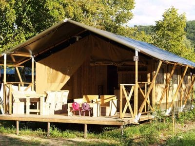 Tente safari en Auvergne, avec terrasse en bois et mobilier en plein air.