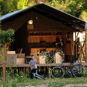 Hébergement insolite en Auvergne : cabane en bois avec terrasse et vélo.