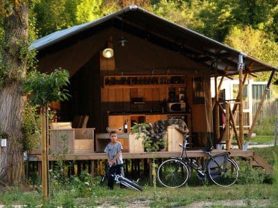 Hébergement insolite en Auvergne : cabane en bois avec terrasse et vélo.