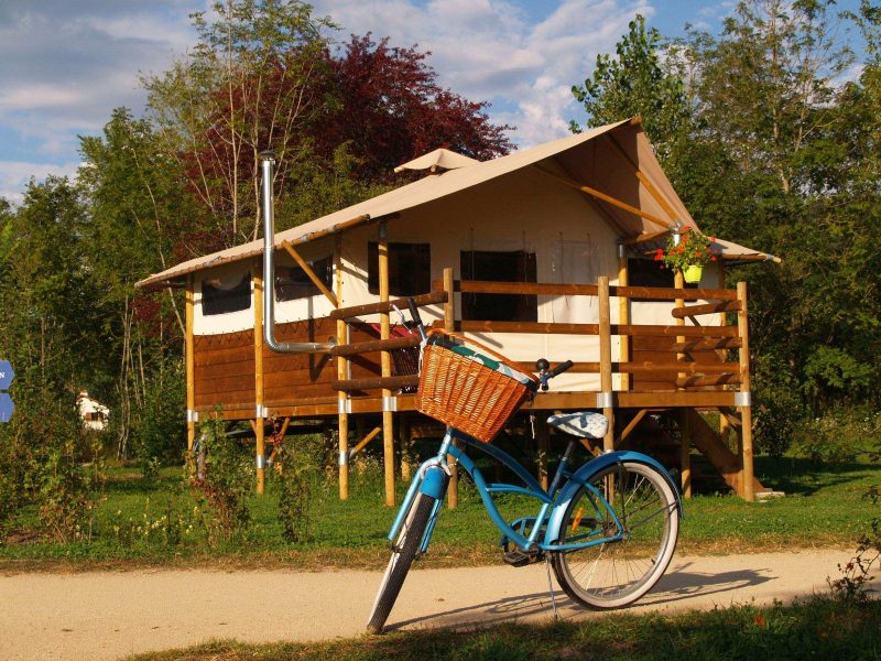 Cabane sur pilotis en Auvergne, avec une belle terrasse et un vélo vintage.
