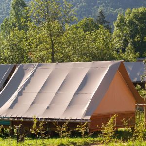 Tente safari en Auvergne, nichée dans la verdure, offrant un cadre naturel apaisant.