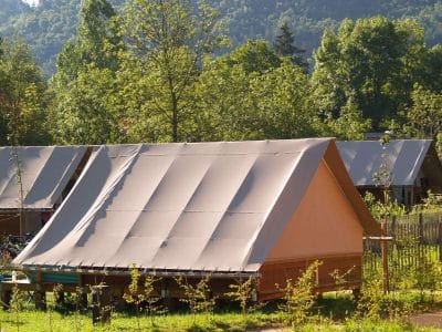 Tente safari en Auvergne, nichée dans la verdure, offrant un cadre naturel apaisant.