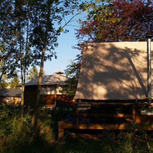 Tentes safari en bois, nichées dans la verdure dAuvergne, offrant un cadre paisible.