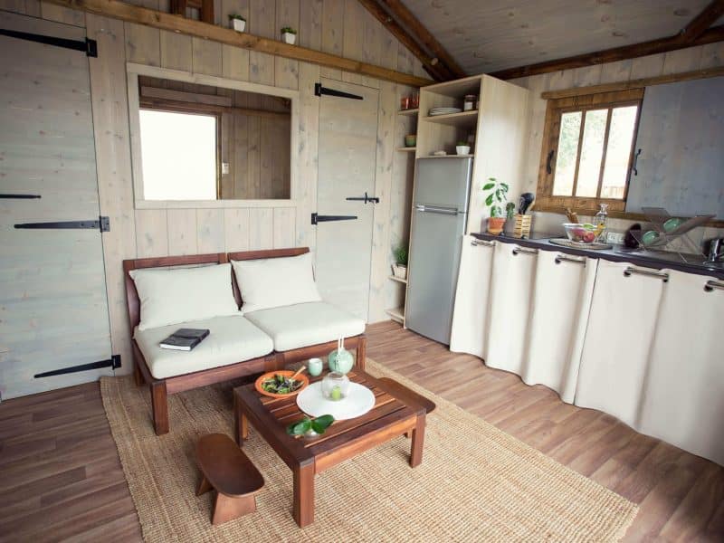 Hébergement insolite en Auvergne : chalet en bois avec cuisine et coin salon accueillant.