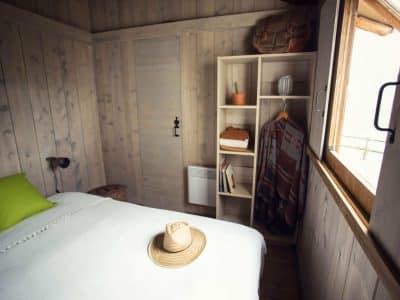 Chalet en bois chaleureux avec lit douillet et décoration naturelle.