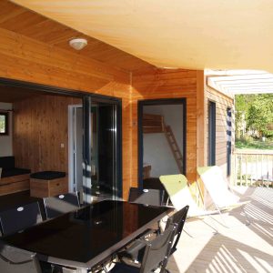 Hébergement insolite en Auvergne : chalet en bois avec terrasse et mobilier moderne.