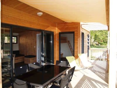 Hébergement insolite en Auvergne : chalet en bois avec terrasse et mobilier moderne.