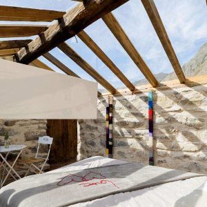 Chalet en pierre avec toit en bois, lumineux et cosy, idéal pour un séjour en montagne.