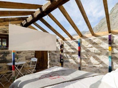 Chalet en pierre avec toit en bois, lumineux et cosy, idéal pour un séjour en montagne.