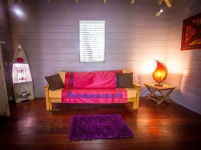 Hébergement insolite : un chalet coloré avec un canapé et une lampe design chaleureuse.