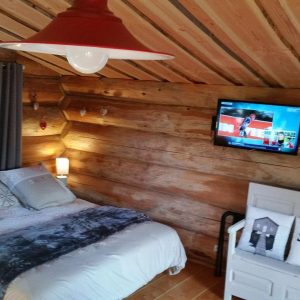 Chalet en bois à Champagne-Ardennes, avec lit douillet et télévision murale.