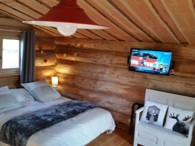 Chalet en bois à Champagne-Ardennes, avec lit douillet et télévision murale.