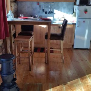Cabane en bois à Champagne-Ardennes, avec cuisine lumineuse et poêle à bois.