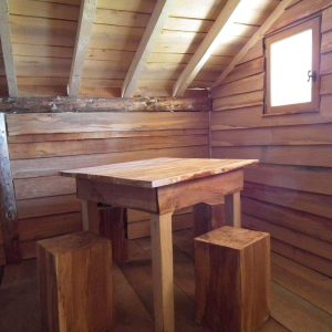 Cabane en bois dans le Grand-Est, avec une table en bois massif et des bancs rustiques.