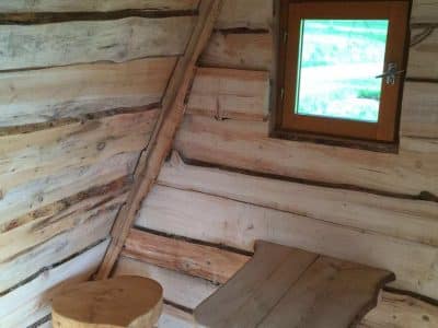 Cabane en bois dans le Grand-Est, avec un mobilier en bois naturel et une fenêtre lumineuse.