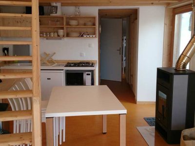 Hébergement insolite en bois à Grand-Est, avec cuisine moderne et poêle à bois.