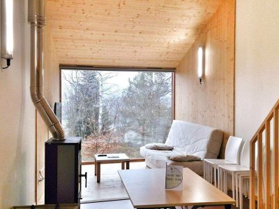 Hébergement insolite en bois à Grand-Est, avec un salon lumineux et vue sur la nature.