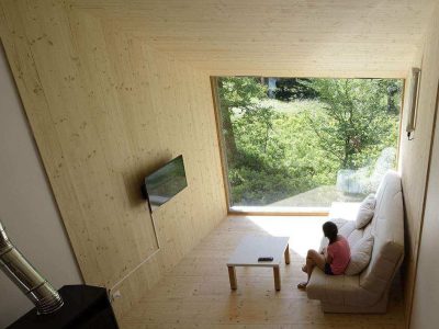 Hébergement insolite en bois à Grand-Est, avec grande fenêtre sur la nature.