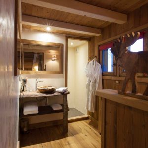 Chalet en bois chaleureux avec salle de bain moderne et décor montagnard.
