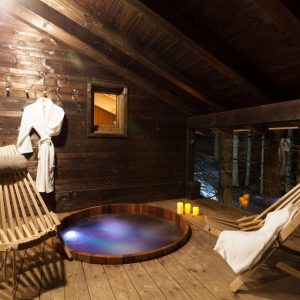 Hébergement insolite en Auvergne-Rhône-Alpes avec un jacuzzi et des fauteuils en bois.