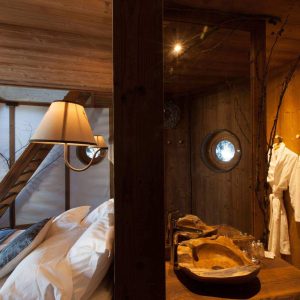 Chalet en bois avec lit douillet et salle de bain au design naturel et chaleureux.