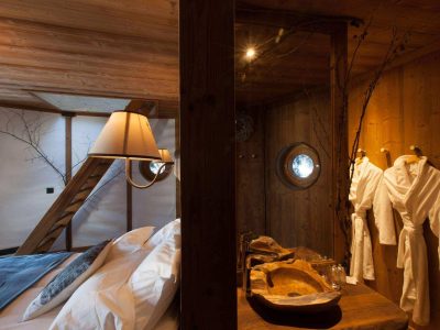 Chalet en bois avec lit douillet et salle de bain au design naturel et chaleureux.